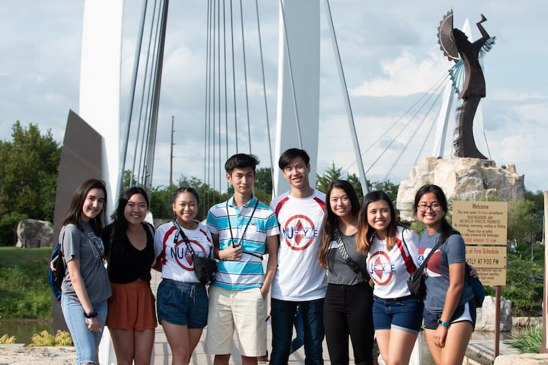 Newman University students standing in front of the famous Keeper of the Plains statue in Wichita